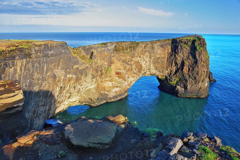 The cape Dirkholaey in the south of Iceland. The enormous rock elephant it is lit with a summer. The sunset in July