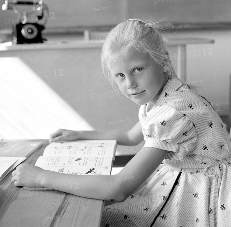 School in the 1950s. A girl is seen sitting at her desk in the classroom reading from the schoolbook in front of her. Sweden 1957 Conard ref 3538