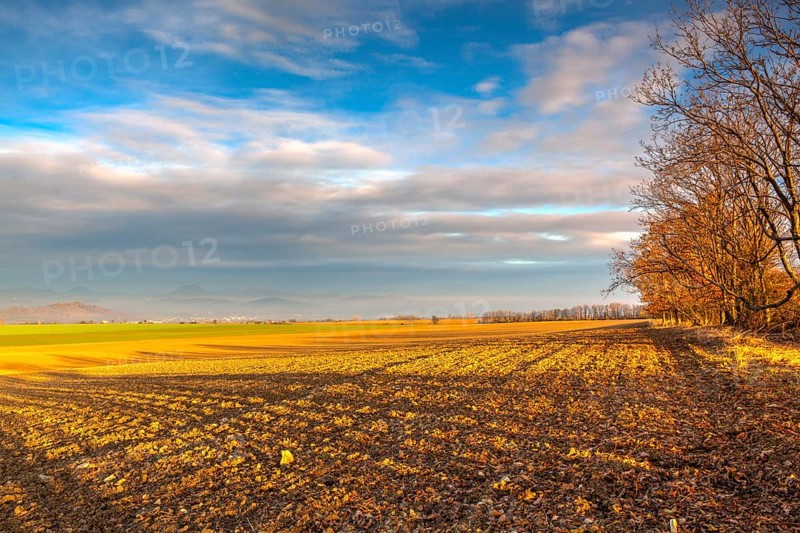 Autumn morning landscape over the city of Louny. Autumn plowed field at amazing sunrise. Czech Republic