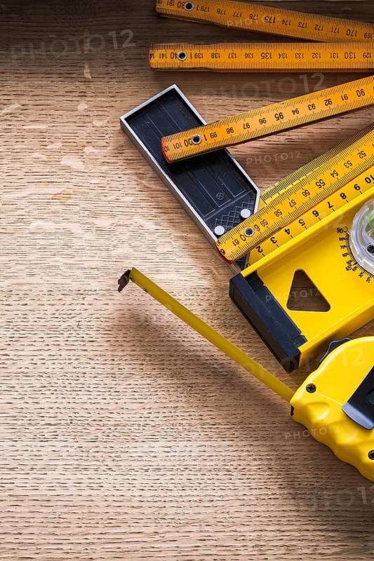Oak board with wooden meter measuring tape construction level and square ruler construction concept