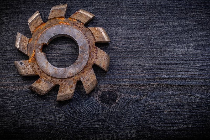 Vintage milling cutter with cogs on wood board construction concept
