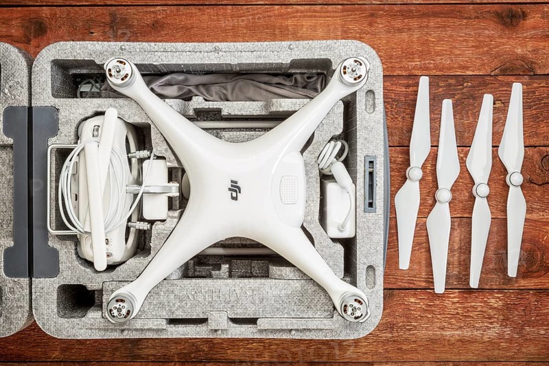FORT COLLINS, CO, USA - DECEMBER 11, 2016: DJI Phantom 4 pro quadcopter drone in a custom case on a rustic wooden table with a set of propelelrs