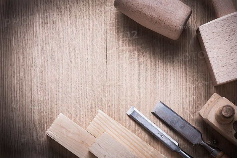 Wooden bricks mallets planner flat chisels on wood background construction concept