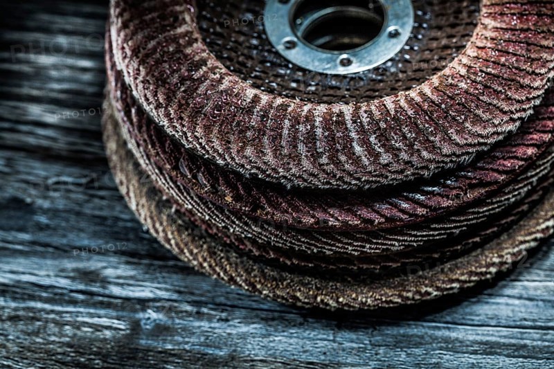 Pile of rotary abrasive discs on wooden board