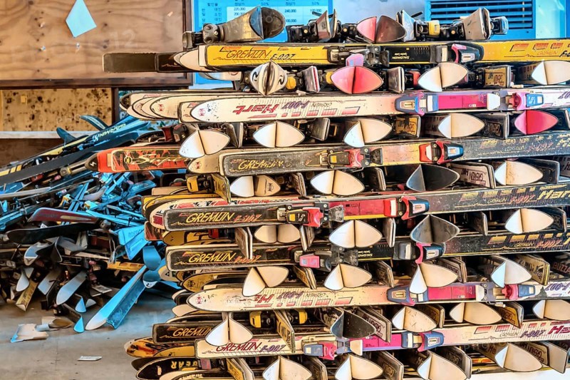 Goesan, South Korea. May 29, 2020: Snow skis from various manufactures stacked in rows in sunlit room at abandoned bankrupt ski resort