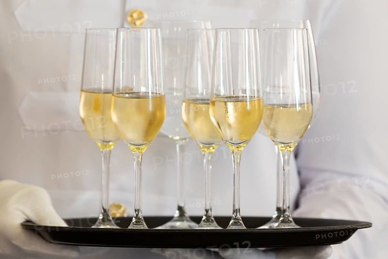 Waiter holds a tray of white wine, champagne and water