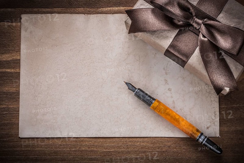 Present box brown bow paper fountain pen on wood board