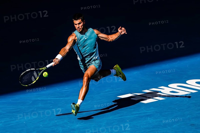 MELBOURNE, AUSTRALIA - JANUARY 19: Carlos Alcaraz of Spain hits a forehand to Jack Draper of Great Britain on day eight of the 2025 Australian Open at Melbourne Park on January 19, 2025 in Melbourne, Australia, Oceania