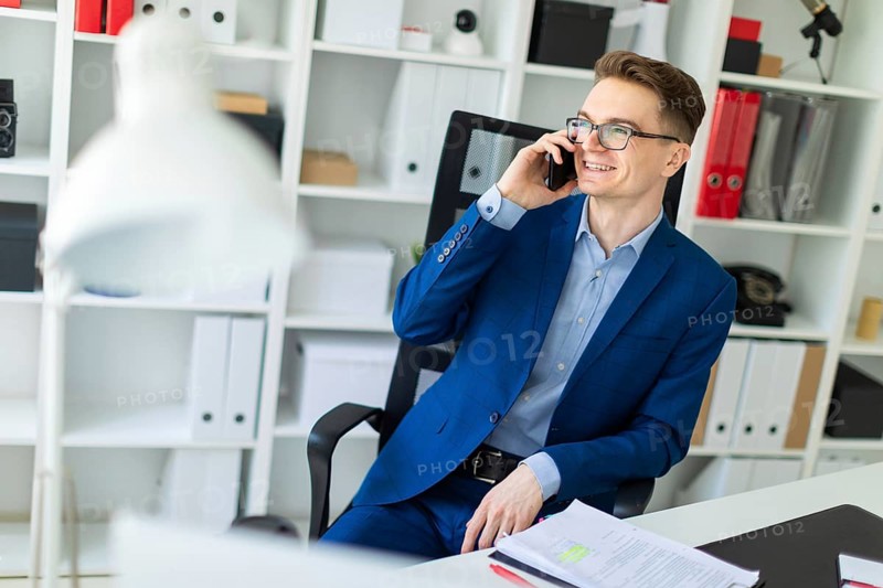 Casual businessman working in office, sitting at desk, typing on keyboard, looking at computer screen
