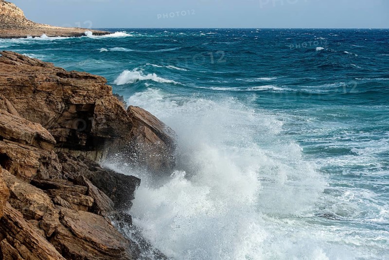Waves crashing on rocky coast. Windy weather, Powerful sea waves braking on rocks