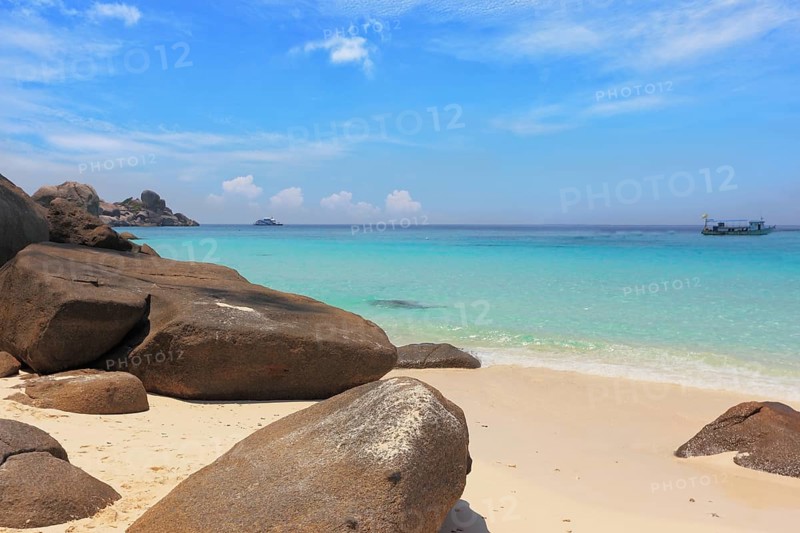 Similan Islands, Andaman Sea, Thailand. Finest white sand beach adjacent to the great brown cliffs and azure water. Unusual beach