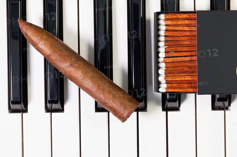 Detail of piano keyboard and luxury cigar