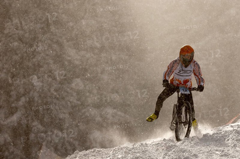 Sofia, Bulgaria - 22 January, 2022: Cyclist rides a bike downhill during an extreme snow riding mountain bicycle competition in Vitosha mountain