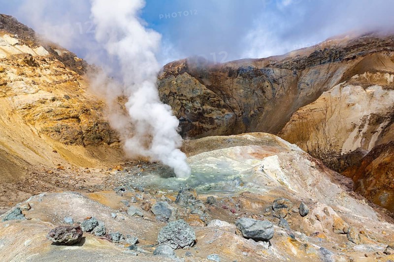 Scenery view of crater of active volcano, amazing volcanic landscape: hot spring and fumarole, lava field, gas-steam activity. Travel destinations for mountain climbing, active vacation and hiking