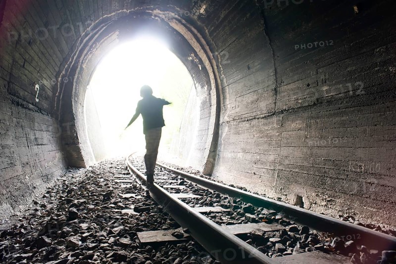 Child walking in railway tunnel. Vintage clothes