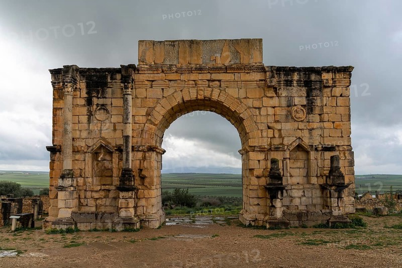 Volubilis, Morocco, 3 March, 2024: view of the ruins of the Triumphal Arch and city gate in the ancient Roman Berber city of Volubilis in Morocco, Africa
