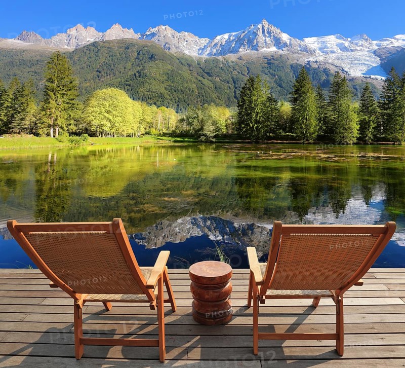 Comfortable lounge chairs on wooden platform for rest and observation. City park in the Alpine resort of Chamonix