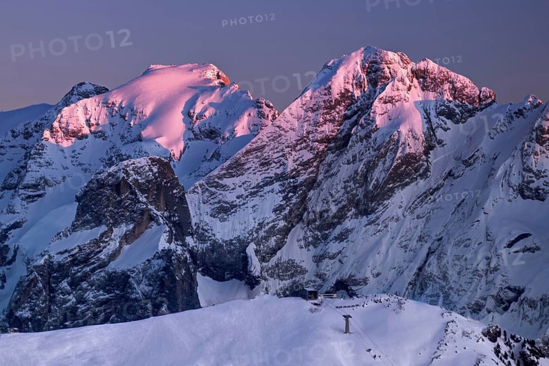View from the top of Marmolada on the surrounding Dolomite hills after sunrise in winter
