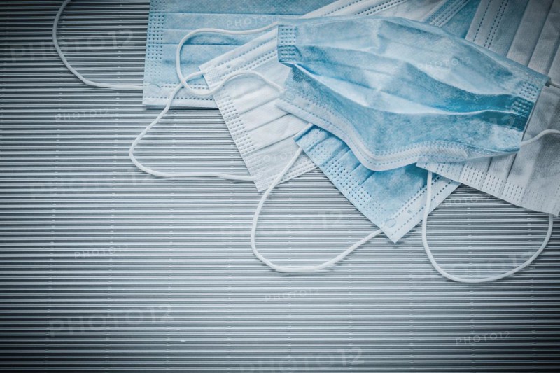 Horizontal image of disposable face masks on a striped background