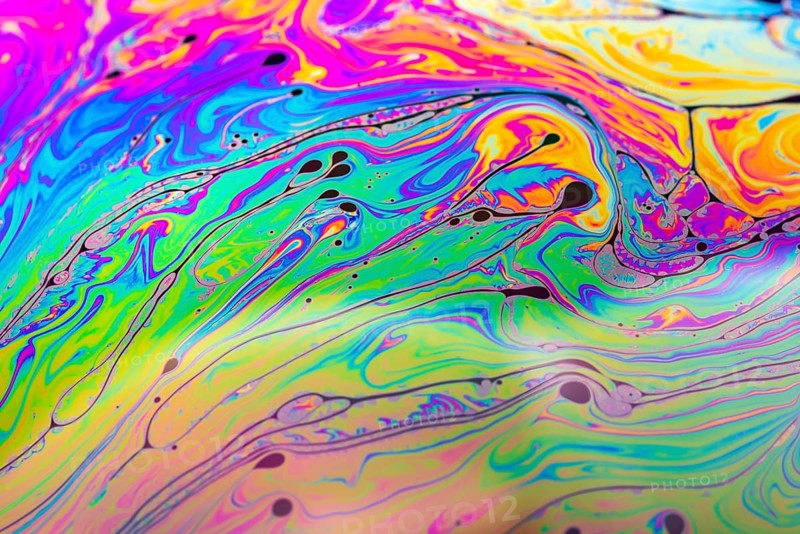 Abstract background made from soap bubble reflecting light. Rainbow soap bubble on a dark background