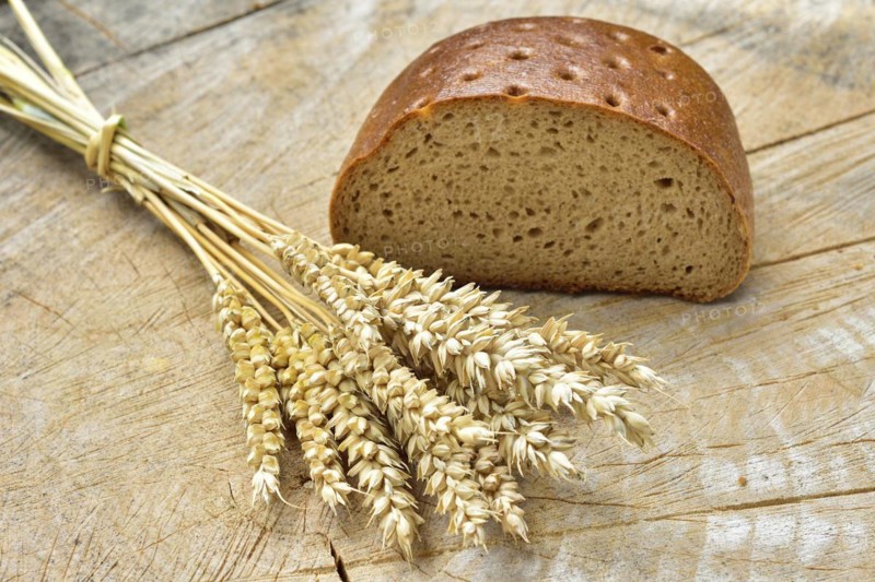 Cereal, wheat and bread on a wooden table. Different types of bread on wood