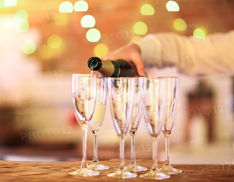 Champagne glasses on wooden table in bright lights. Party or celebration