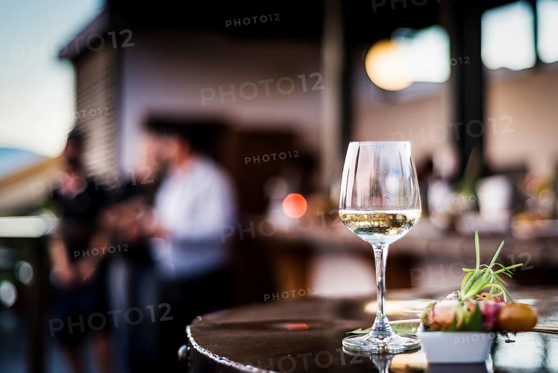 Glass of white wine with gourmet food tapa snacks in outdoors bar at sunset