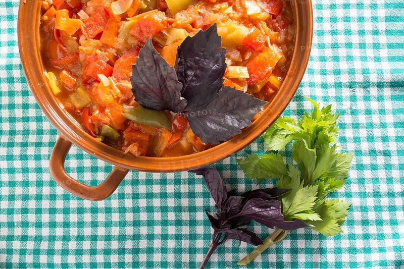 Closeup of delicious stew with mixed vegetables, arranged with green and purple leaves