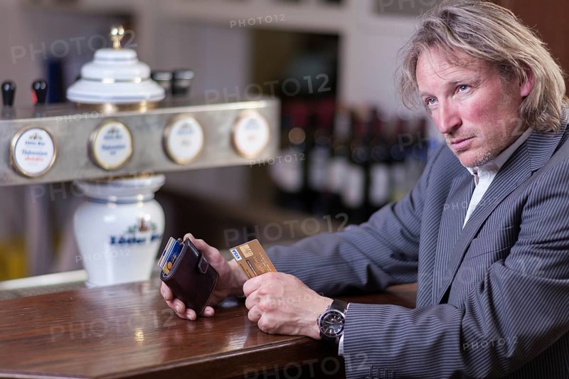 Man in suit paying at a counter with a credit card, Mindelheim, Bavaria, Germany, Europe