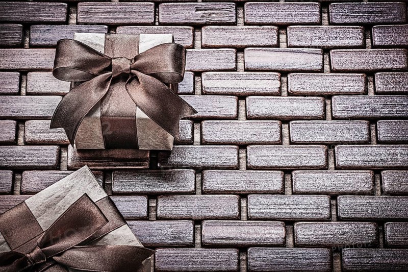 Presents packed with tied ribbons on wooden mat holidays concept