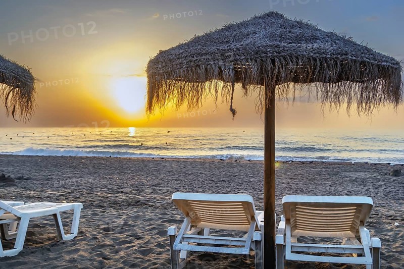 Sunbed and umbrella on the sunset background, Torremolinos, Spain, Europe