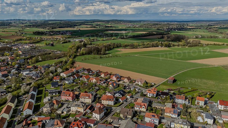 Aerial view of a neighbourhood with numerous houses and surrounding fields under a cloudy sky, Mitterteich, Upper Palatinate, Bavaria, Germany, Europe