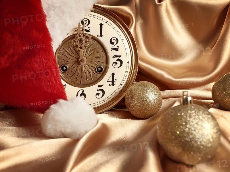 New year theme with balls, vintage clock and Santa hat over golden drapery