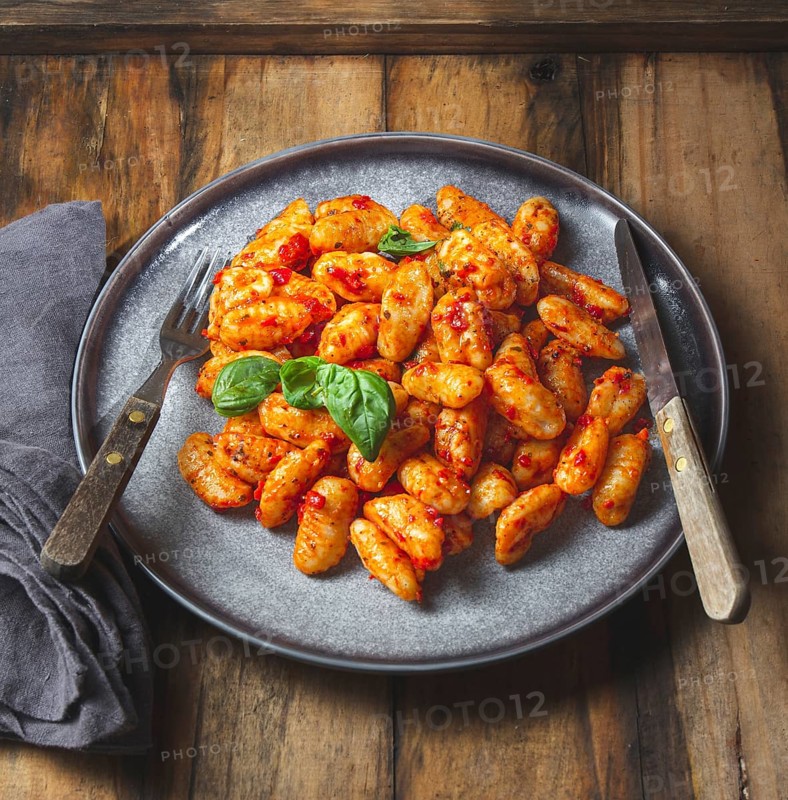 Food, Traditional Italian potato Gnocchi with tomato sauce and fresh basil on blue plate on wooden background