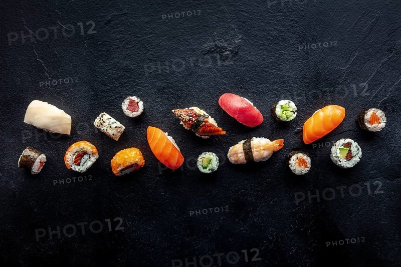 Sushi overhead flat lay shot. Rolls, maki, nigiri on a black slate background, Japanese food. Salmon, eel, shrimp, tuna etc with rice, with copy space, Food photography, Food photography