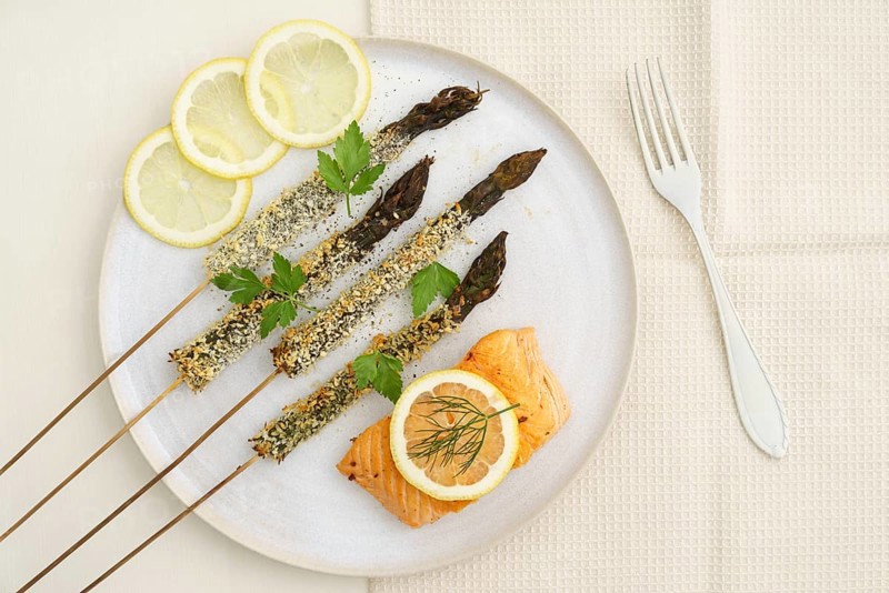 Panko-fried green asparagus on a skewer with salmon and lemon