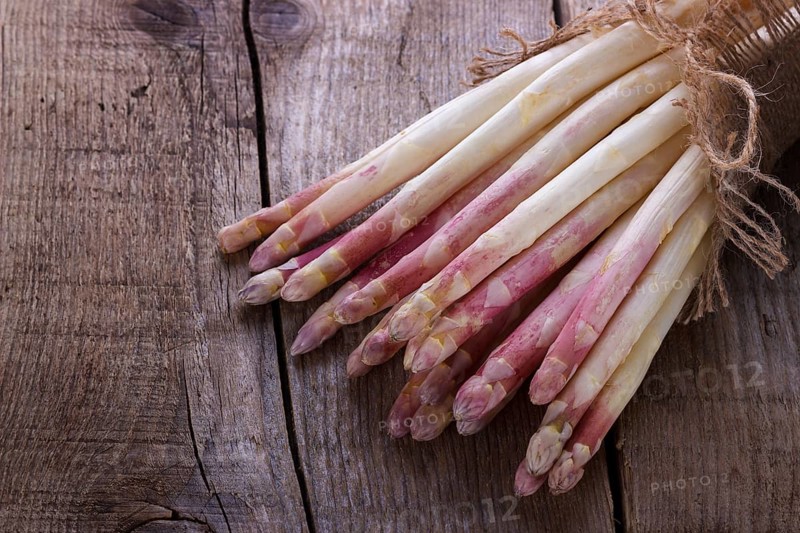 Bunch of fresh white asparagus on old wooden board