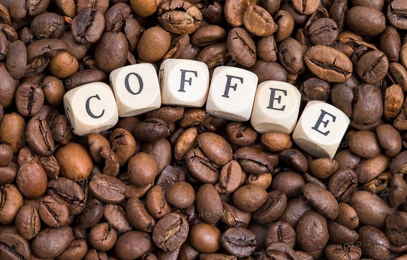 The photo shows roasted coffee beans with wooden letters