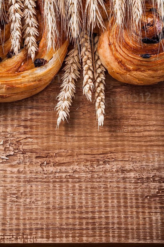Ripe wheat ears rich raisin baked goods on oaken wooden board food and drink concept