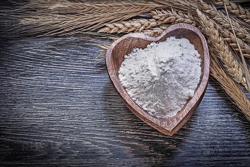 Composition of wooden bowl with flour golden rye wheat ears food and drink concept