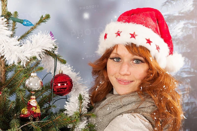Portrait of woman in winter with snow and Christmas tree
