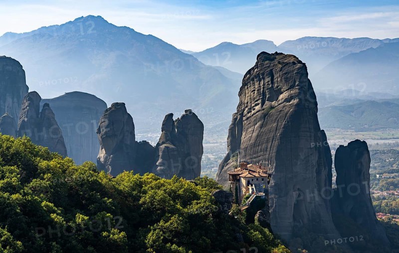 A landscape of the Meteora rock formations with the Saint Nikolaos monastery in the foreground