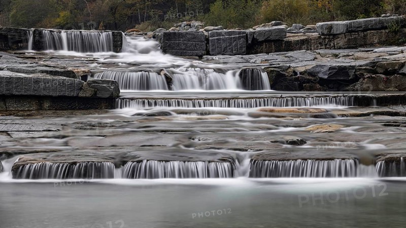 An impressive, multi-levelled waterfall flows over stones in a tranquil natural setting, Val d'Ossola, province of Verbano-Cusio-Ossola, Piedmont, Italy, Europe