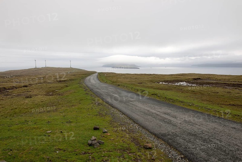Street on the Faroe Islands in the south of Eysturoy with wind mills and nolsoy, Æduvik, Faroe Islands, Europe