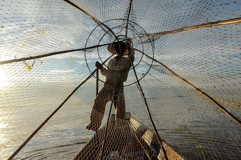 05.03.2014, Nyaung Shwe, Shan State, Myanmar, Asia, A single-leg rower paddles along the northern shore of Inle Lake early in the morning. The lake is located in Shan State in the centre of Myanmar and is home to the Intha people, who live mainly from fishing and farming, Asia