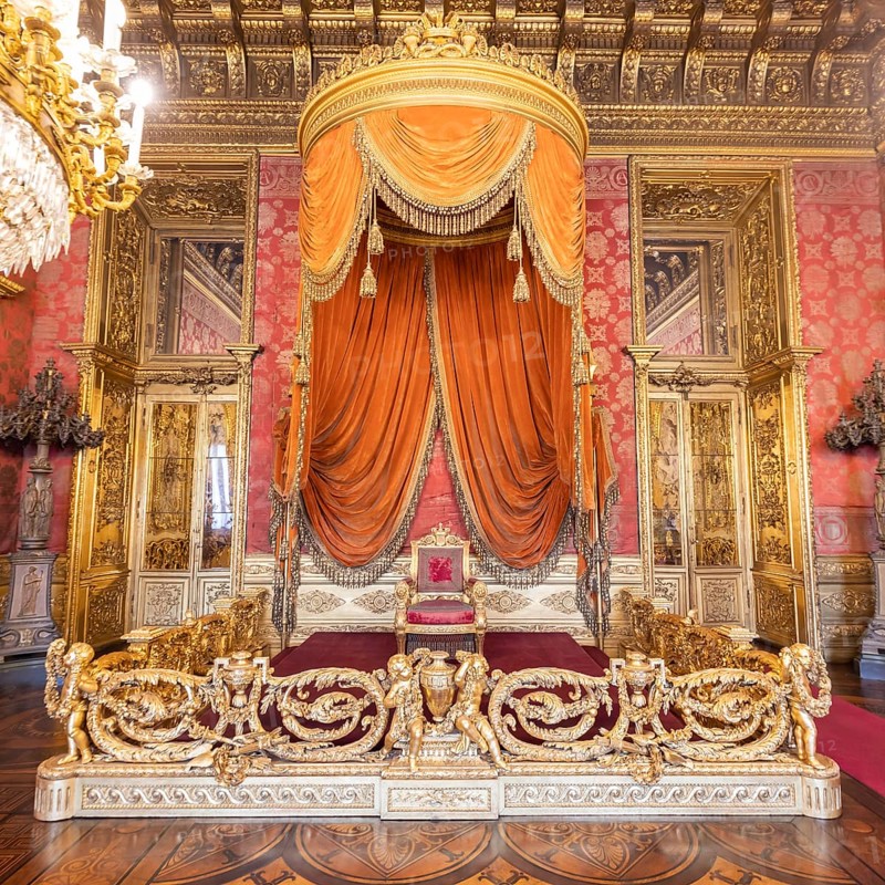 Turin, Italy, Circa August 2021: old throne room interior with chair in luxury palace. Red and gold antique Baroque style, Savoia Royal Palace, Europe