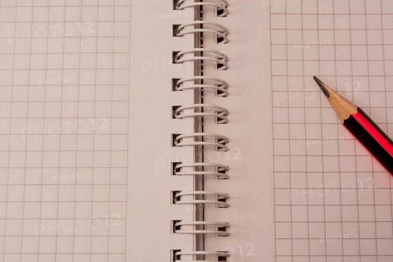 White empty notebook with pencil on top of it
