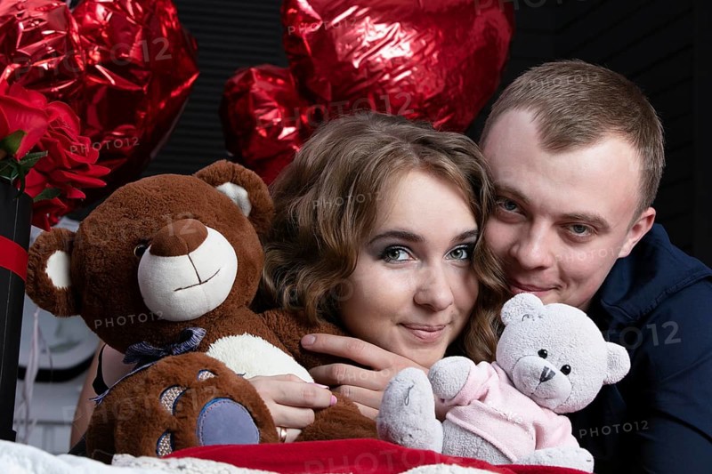 Boyfriend and girlfriend on Valentine's Day. Portrait of lovers. A man and a beautiful woman with flowers and bears