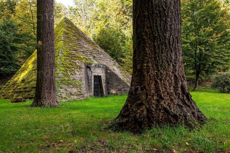 Pyramid-shaped, moss-covered mausoleum, surrounded by tall trees, mystical atmosphere, Hämelschenburg Castle, Weserbergland, Lower Saxony, Germany, Europe
