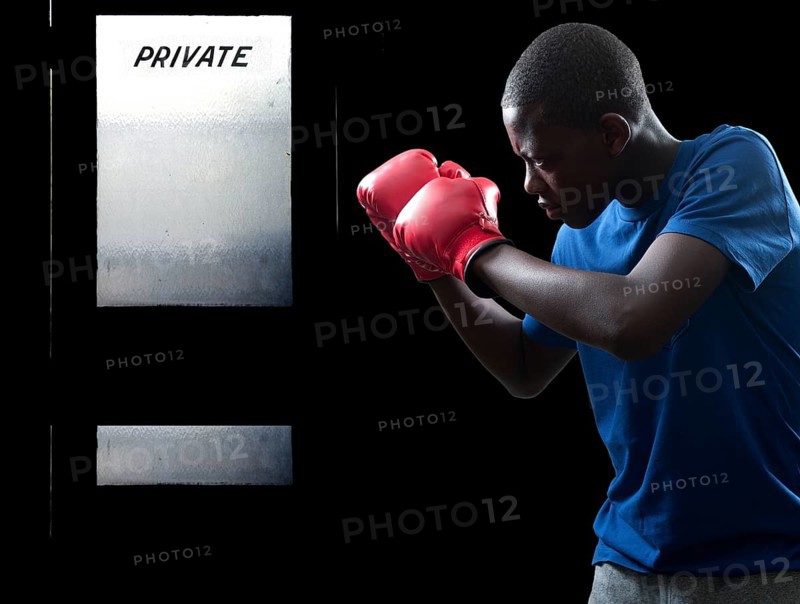 Black African American teenage boy athletic boxer with boxing gloves